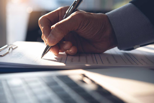 Businessman signing a document to start a franchise.